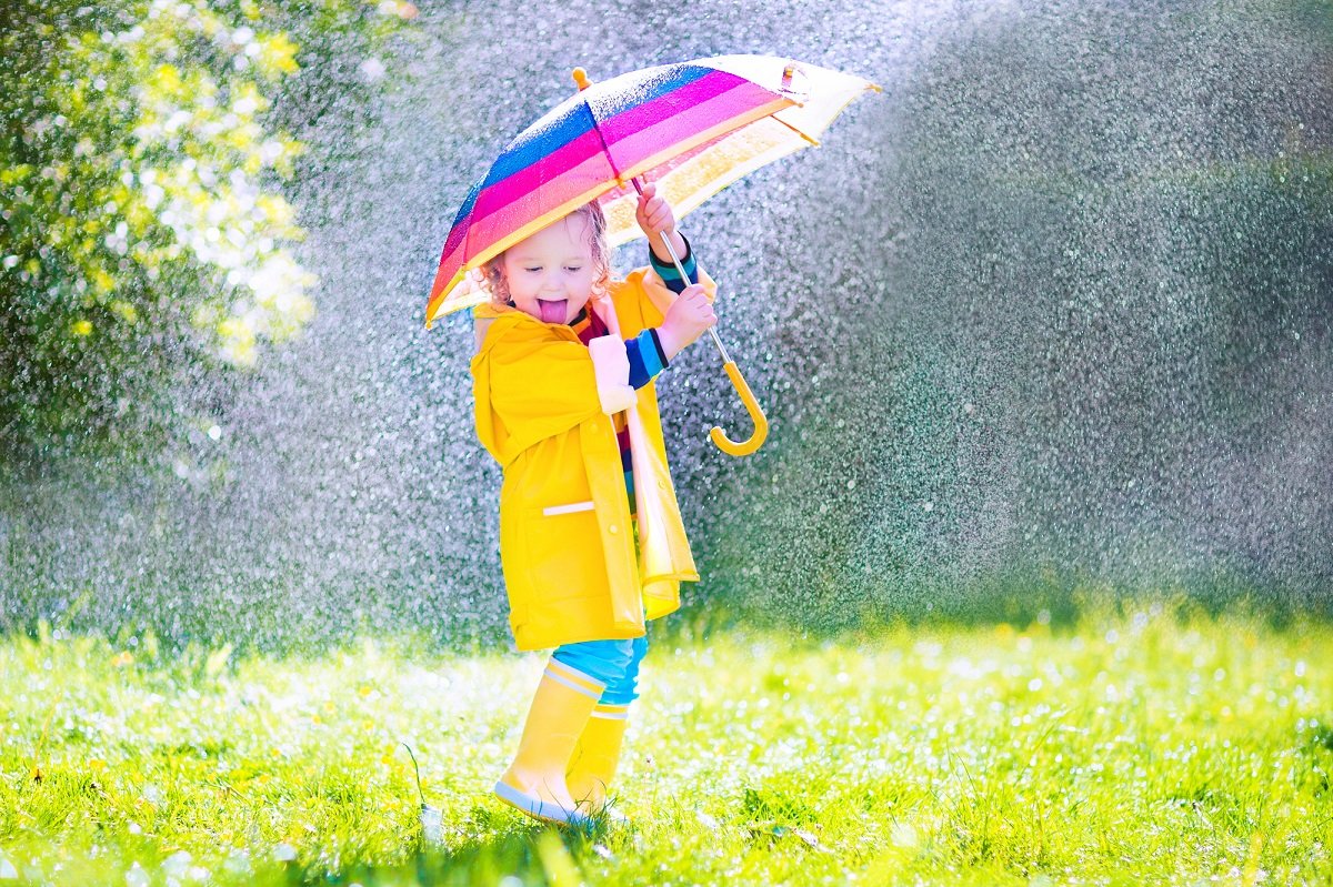 Ребенок под зонтиком под дождем